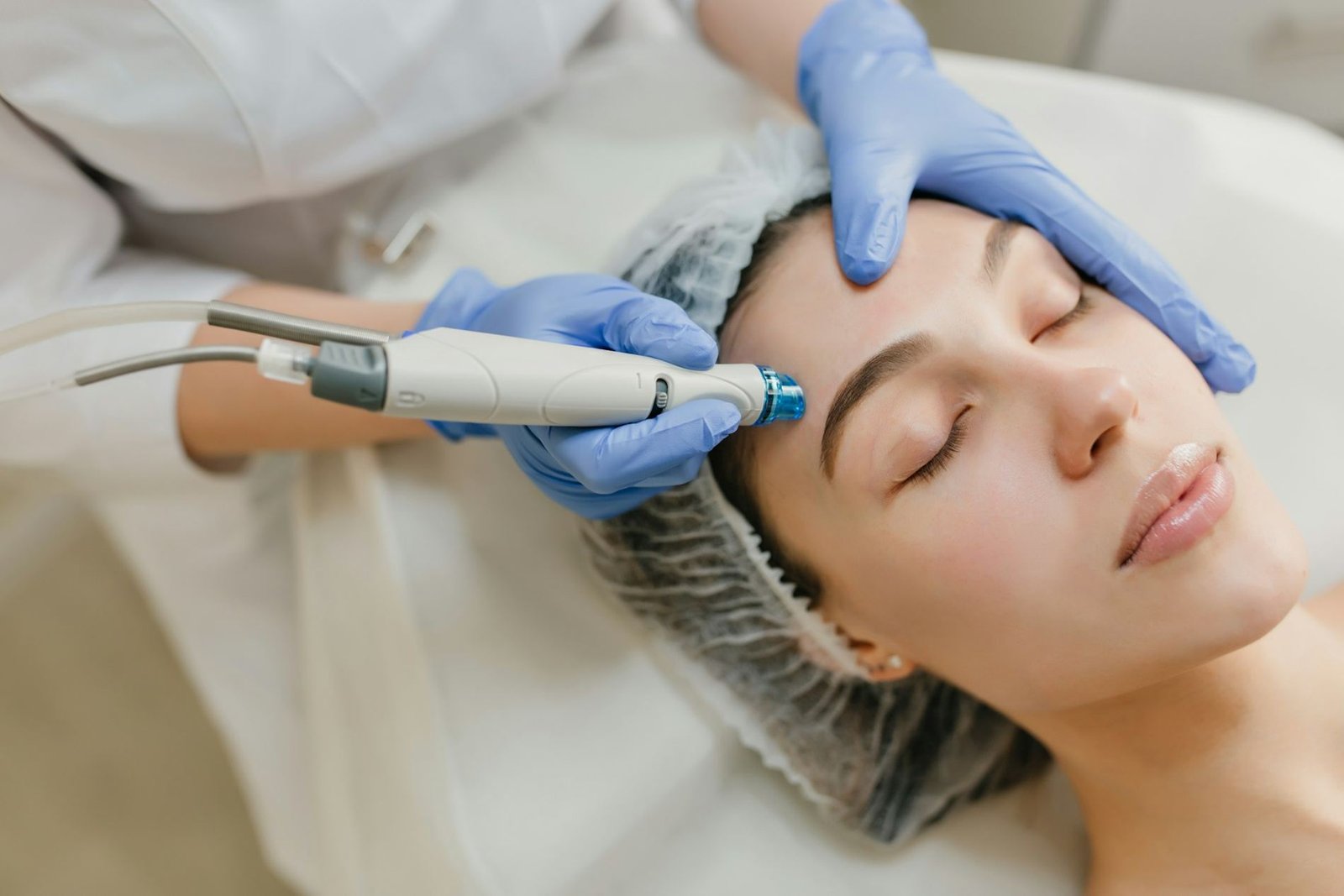 A dermatologist treating a patient’s skin with a handheld device