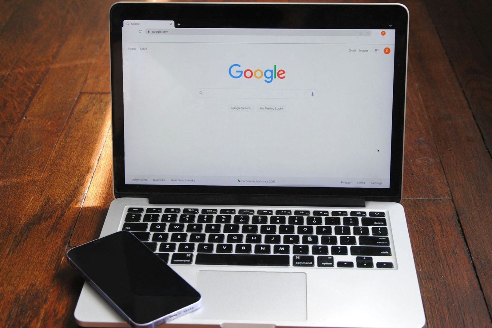 A laptop showing Google on a wooden desk